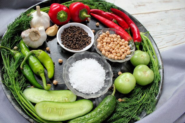 Encurtidos en mesa de madera blanca con pimientos verdes y rojos y ají, hinojo, sal, pimienta negra, ajo, guisantes, primer plano, concepto saludable, vista superior, endecha plana