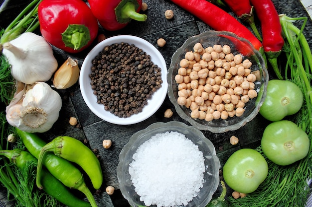 Encurtidos en mesa de madera blanca con pimientos verdes y rojos y ají, hinojo, sal, pimienta negra, ajo, guisantes, primer plano, concepto saludable, vista superior, endecha plana