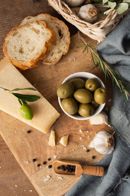 Endecha plana aceitunas parmesanas y ajo en tabla de cortar