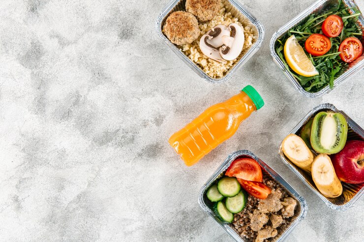 Foto gratuito endecha plana de botella de jugo de naranja con comidas en guisos y espacio de copia