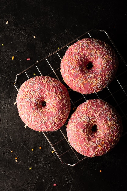 Foto gratuita endecha plana de donas glaseadas decoradas con chispas