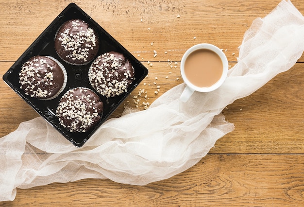 Endecha plana de donas en un plato con café y tela