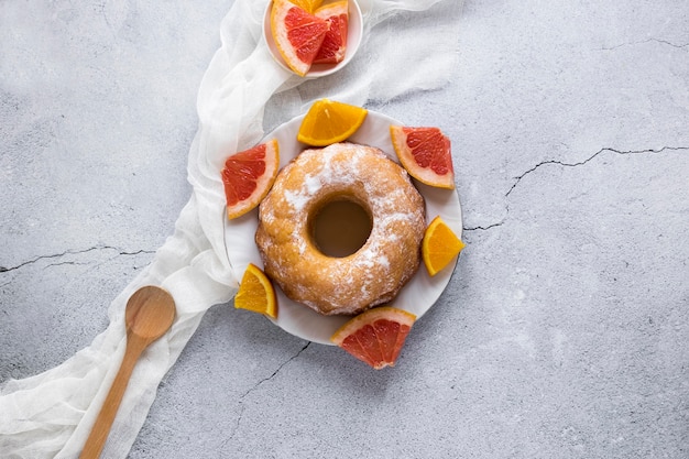 Endecha plana de donut en plato con cítricos