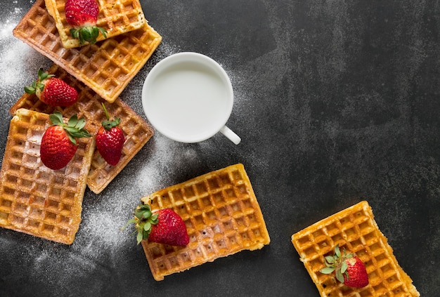 Endecha plana de gofres con leche y fresas