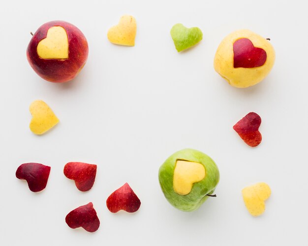 Endecha plana de manzanas y frutas en forma de corazón
