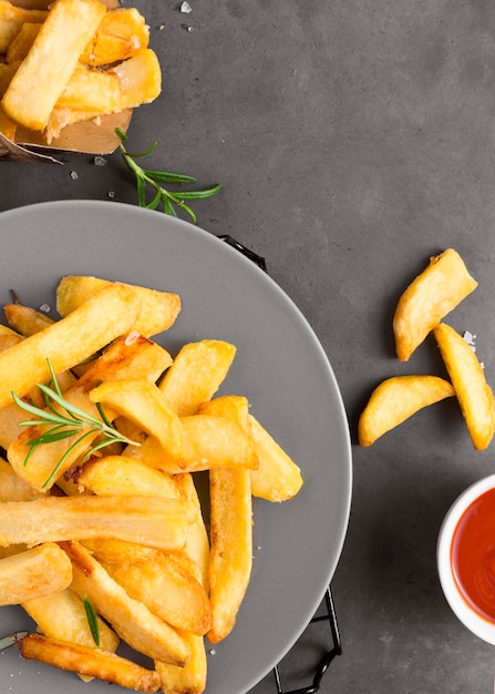 Endecha plana de papas fritas en un plato con salsa de tomate