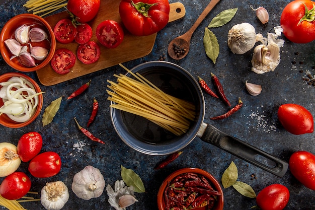 Endecha plana de pasta en una sartén con tomates y verduras