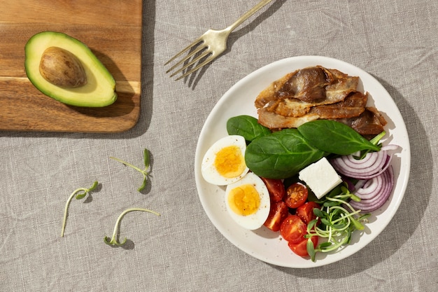 Endecha plana de plato con comida de dieta cetogénica y aguacate