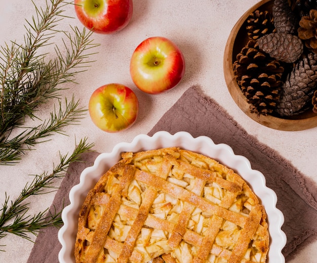 Foto gratuita endecha plana de sabroso pastel de manzana de acción de gracias con piñas