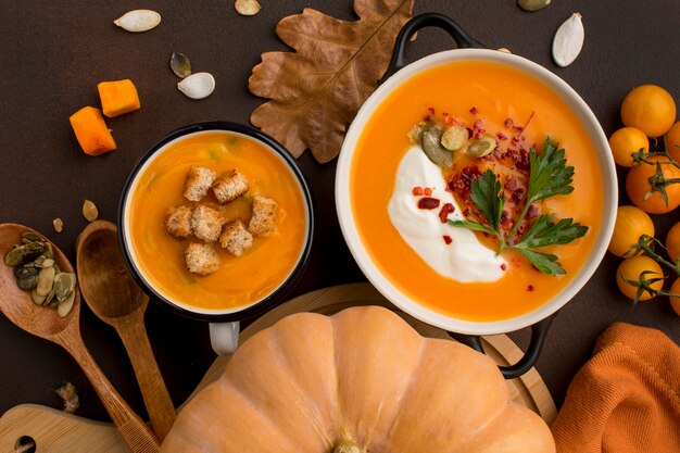 Endecha plana de sopa de calabaza de invierno en un tazón y taza con crutones y perejil