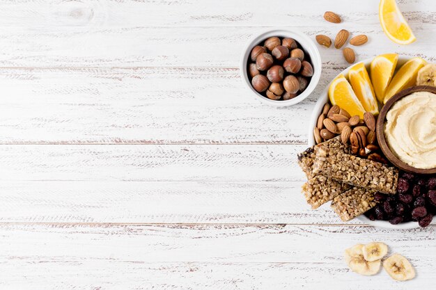 Endecha plana de surtido de nueces en un plato con barras de cereal