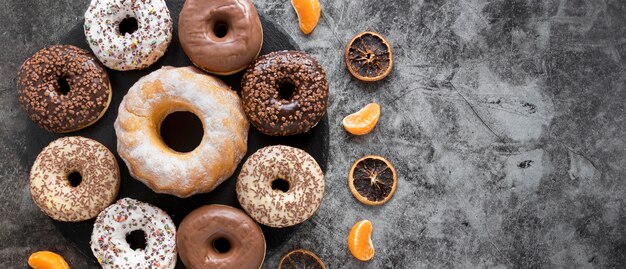 Endecha plana de variedad de donas con cítricos secos y espacio de copia