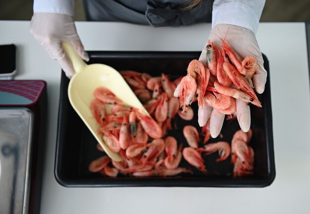 Pescadería muy femenina detrás del mostrador con un pez enorme en sus