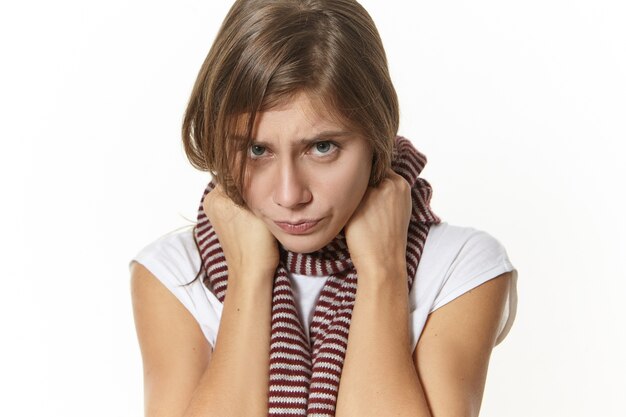 Enfermedad, estado de salud, enfermedad y concepto de enfermedad. Cerrar imagen de niña triste con dolor de garganta posando. Mujer joven deprimida con expresión dolorosa, con síntomas de influenza