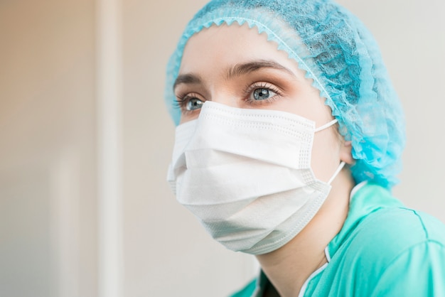 Enfermera de ángulo bajo con máscara en el hospital
