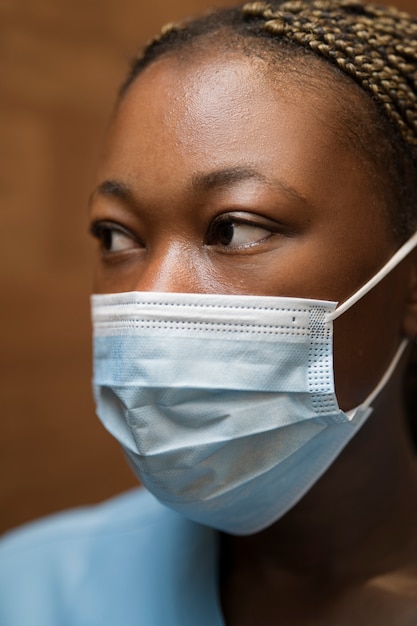 Enfermera con bata y mascarilla médica en la clínica