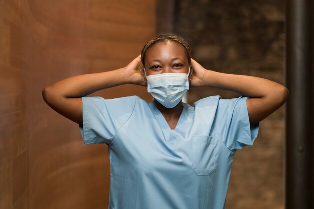 Enfermera con bata y mascarilla médica en la clínica