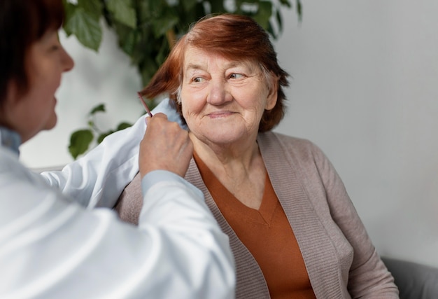 Enfermera cepillarse el cabello de la mujer de cerca