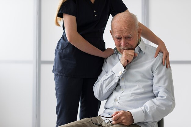 Enfermera consolando a anciano llorando