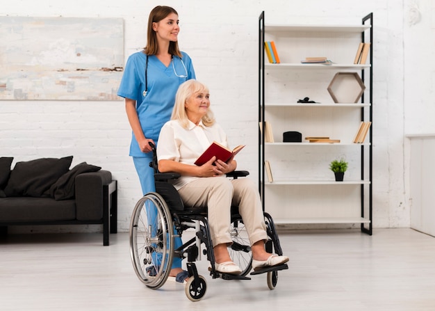 Enfermera cuidando a mujer en silla de ruedas