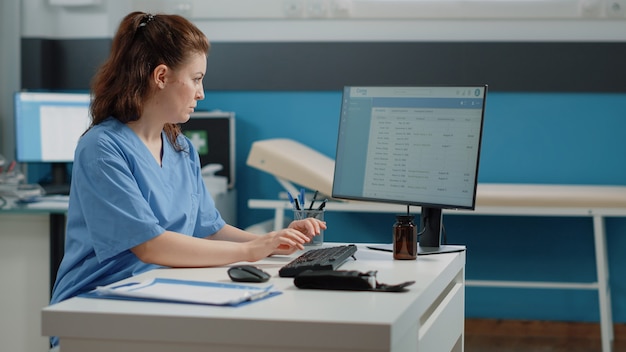 Foto gratuita enfermera escribiendo en el teclado de la computadora para consulta