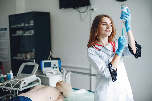 Enfermera con un estetoscopio. Estudiante de práctica de medicina. El doctor realiza procedimientos en la sala.