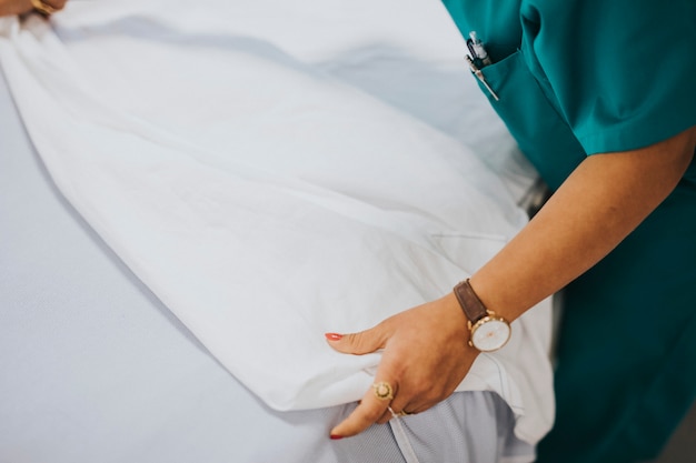 Enfermera haciendo la cama en un hospital.