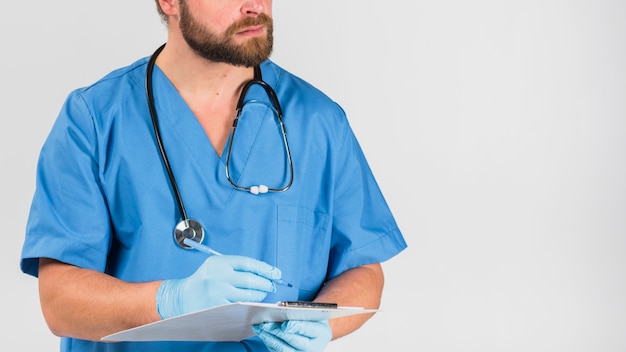 Foto gratuita enfermera hombre sosteniendo y escribiendo en el portapapeles