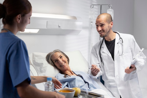 Foto gratuita enfermera y médico de cerca en la habitación del paciente