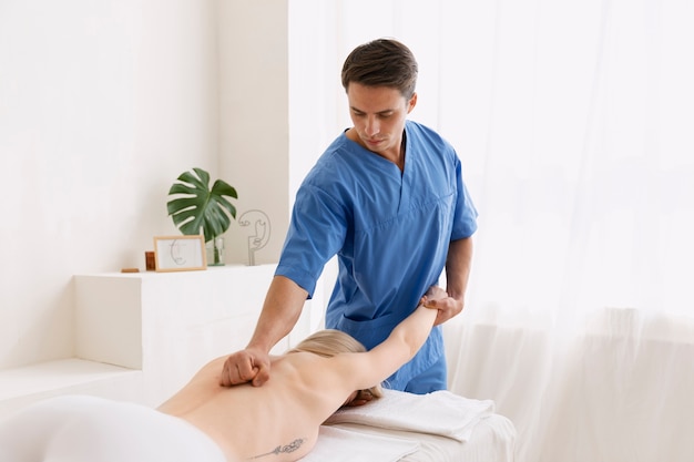 Enfermera con paciente en sesión de osteopatía