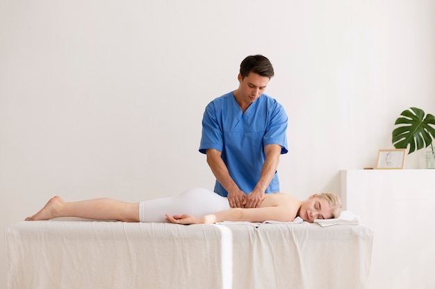 Foto gratuita enfermera con paciente en sesión de osteopatía