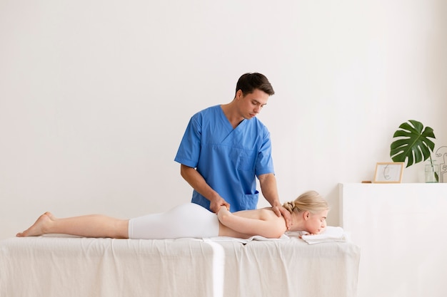 Foto gratuita enfermera con paciente en sesión de osteopatía