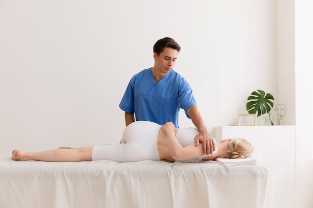 Enfermera con paciente en sesión de osteopatía