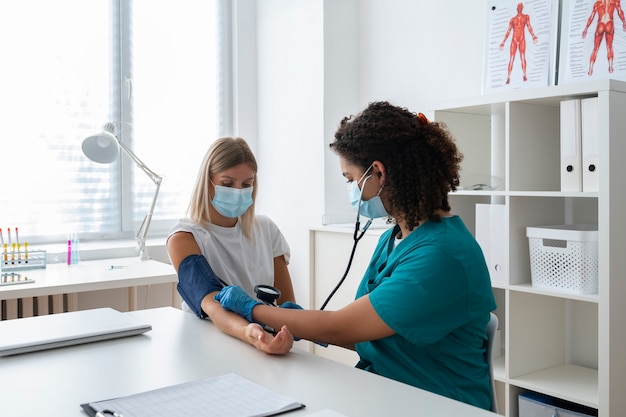 Foto gratuita enfermera practicando medicina en la clínica