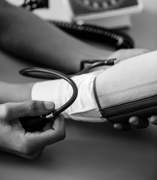 Foto gratuita enfermera que mide la presión arterial del paciente