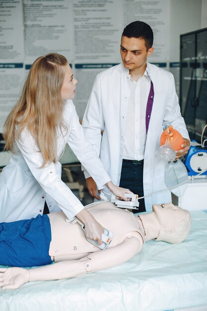 La enfermera realiza la reanimación. El doctor ayuda a la mujer a realizar la operación.