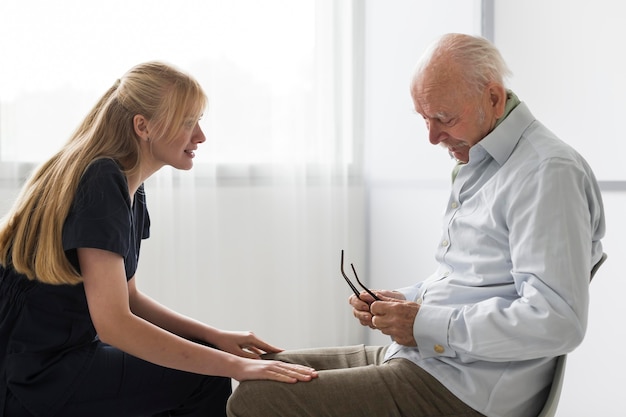 Enfermera tener una conversación con el anciano en un hogar de ancianos