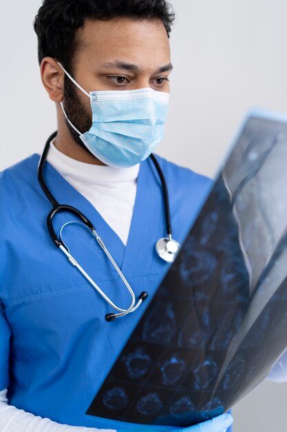 Enfermera de tiro medio mirando radiografía