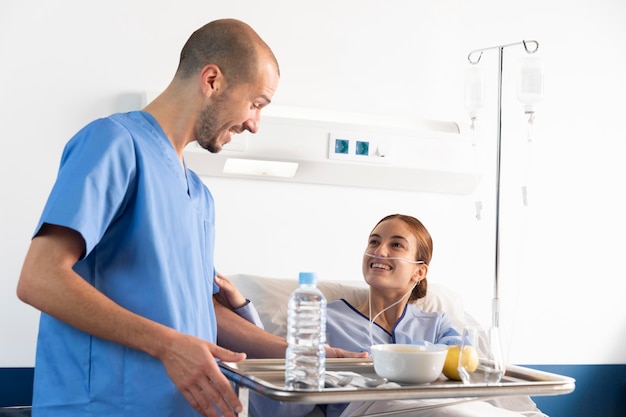 Enfermera de tiro medio sosteniendo la bandeja de comida