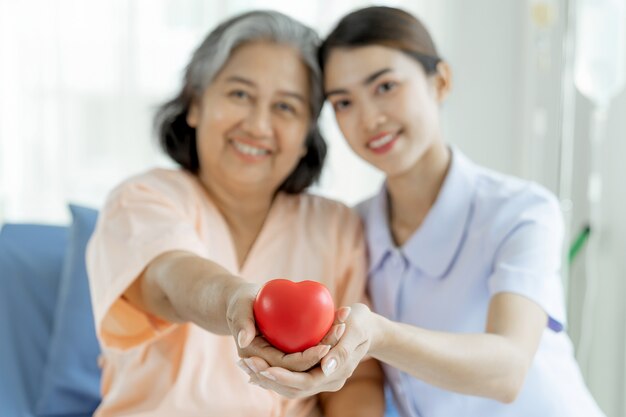 Las enfermeras están muy bien atendidas. Las pacientes de edad avanzada que se encuentran en cama de hospital sienten felicidad: concepto médico y sanitario.