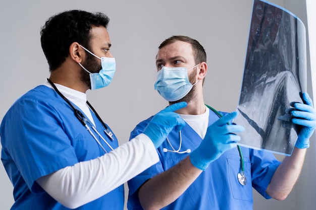 Foto gratuita enfermeras que miran el tiro medio de la radiografía