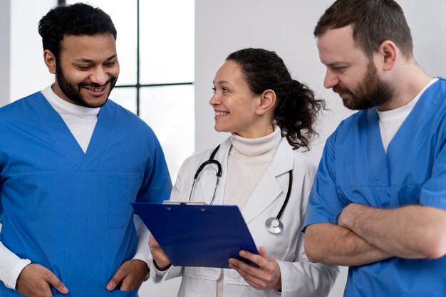 Enfermeras sonrientes discutiendo con el médico tiro medio