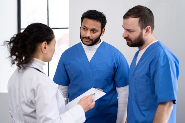 Enfermeras de tiro medio discutiendo con el médico