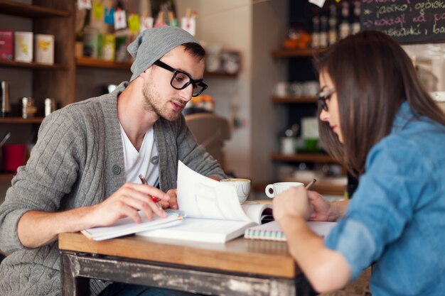 Enfoque a los estudiantes universitarios que se preparan para los exámenes en el café