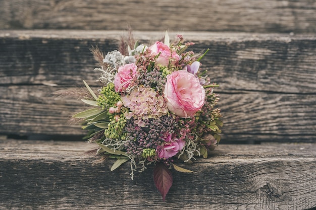 Enfoque selectivo de un hermoso ramo de flores pequeñas sobre una superficie de madera