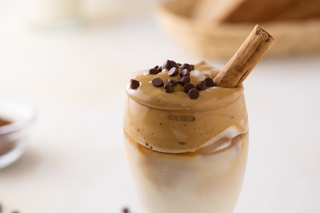 Enfoque suave de café dalgona cubierto con chispas de chocolate y una ramita de canela