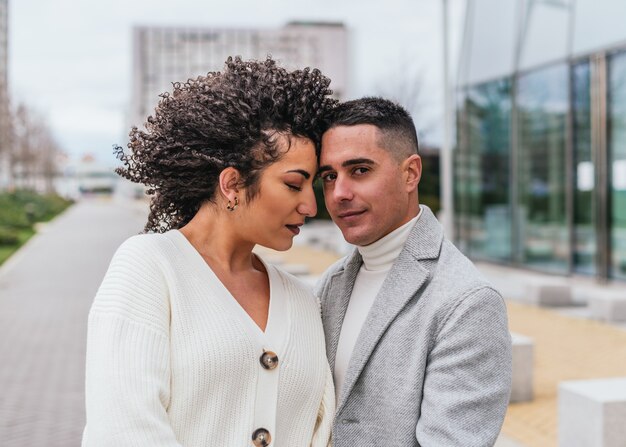 Enfoque superficial de una pareja joven posando juntos al aire libre