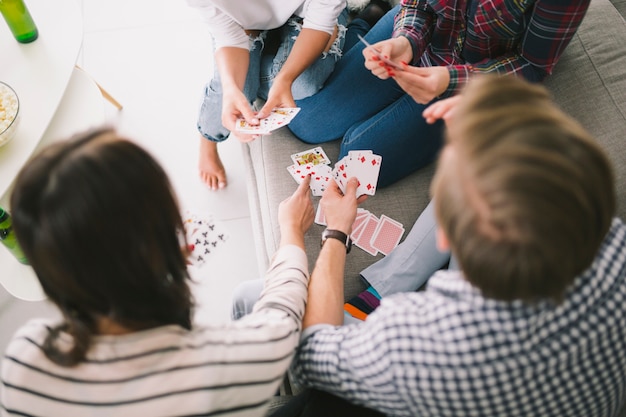 Enfriar gente jugando a las cartas en el sofá