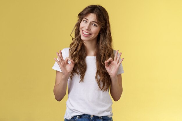 Enfriar todo bien bajo control. La niña muestra el gesto de los anillos ok sonriendo aceptando una buena elección aprobando el asentimiento, el juicio, la opinión personal, el desempeño excelente, tirando de la cara, no con la mala expresión