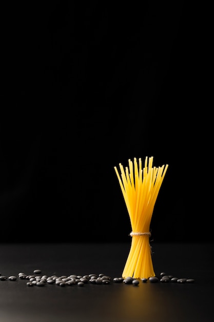 Foto gratuita enlace de pasta con frijoles sobre un fondo oscuro